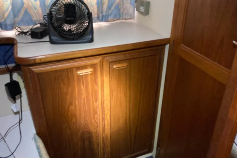 Slide: The Image of Wooden cabinet with a fan on top inside a 1989 Knight & Carver 3807 boat. - 25