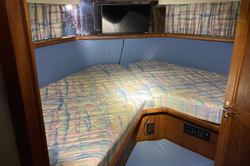 Slide: The Image of Cozy cabin interior of 1989 Knight & Carver 3807 yacht with twin beds and plaid bedding. - 29
