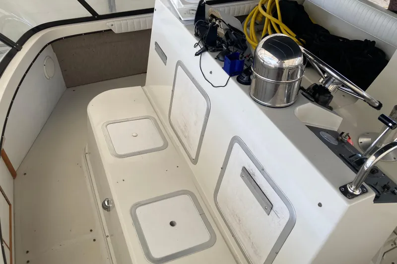 Slide: The Image of Interior of a 1989 Knight & Carver 3807 boat, featuring storage compartments and equipment. - 9