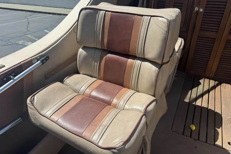 Slide: The Image of Vintage 1985 Invader 20 boat seat with brown and beige upholstery, wooden deck background. - 12