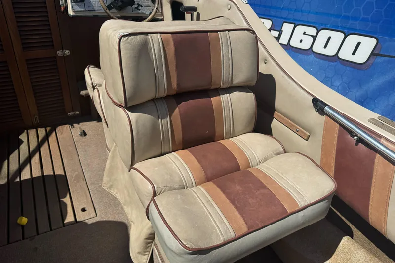 Slide: The Image of Vintage 1985 Invader 20 boat interior with beige and brown cushioned seating. - 13
