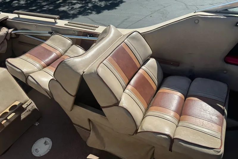 Slide: The Image of 1985 Invader 20 boat interior with vintage brown and beige striped seats. - 14