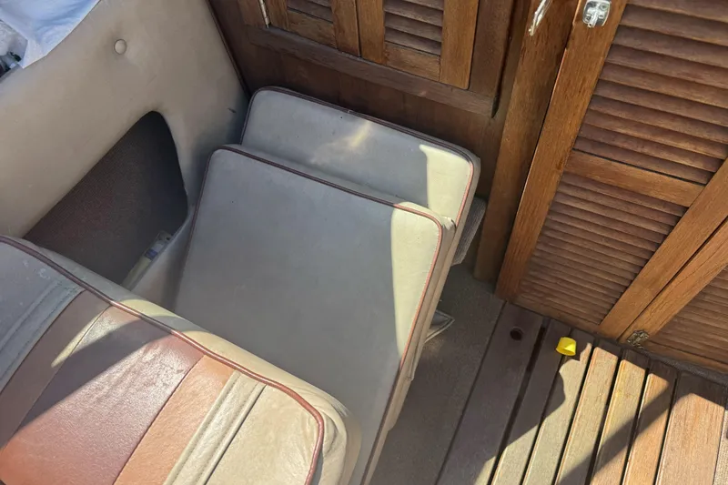 Slide: The Image of Interior of a 1985 Invader 20 boat, featuring wooden panels and cushioned seating. - 17