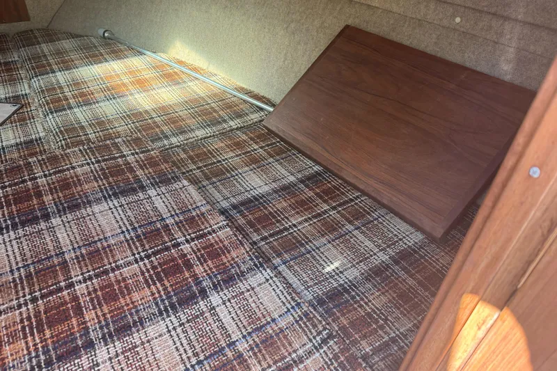 Slide: The Image of 1985 Invader 20 interior with plaid upholstery and wooden paneling. - 21