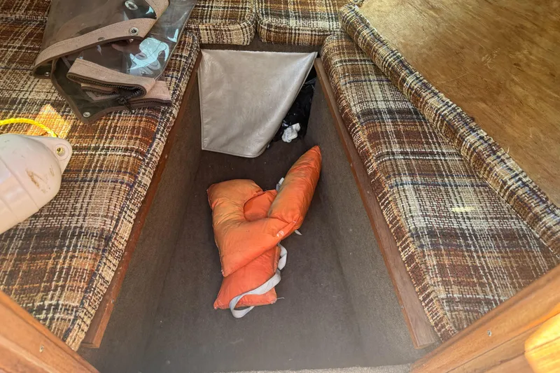 Slide: The Image of Interior of 1985 Invader 20 boat with plaid seating and life jacket. - 22