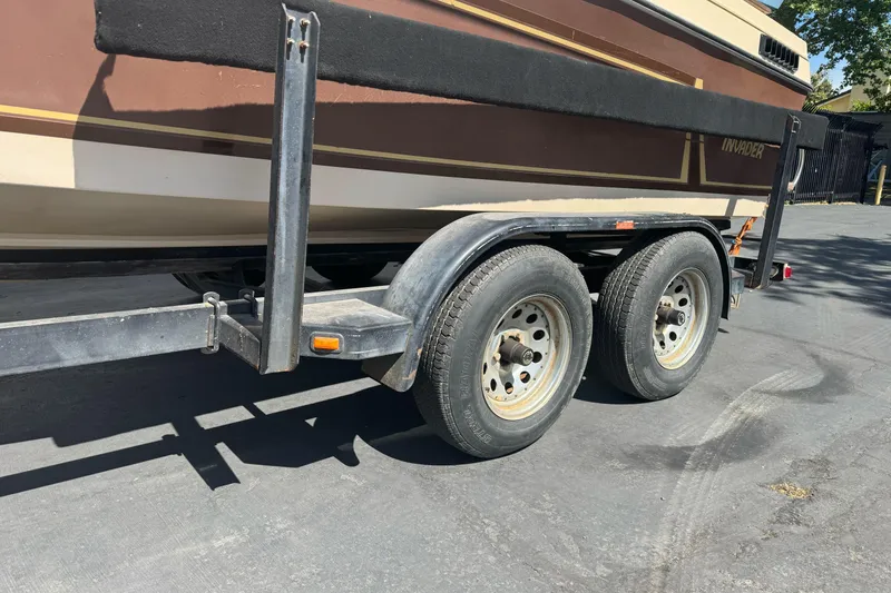 Slide: The Image of 1985 Invader 20 boat on a dual-axle trailer, brown and beige color scheme. - 3