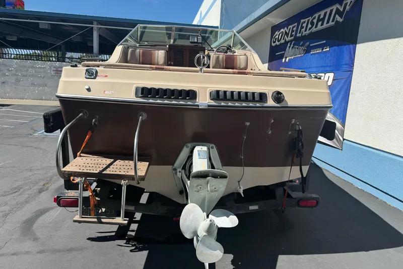 Slide: The Image of 1985 Invader 20 boat on trailer, rear view, parked outdoors. - 5