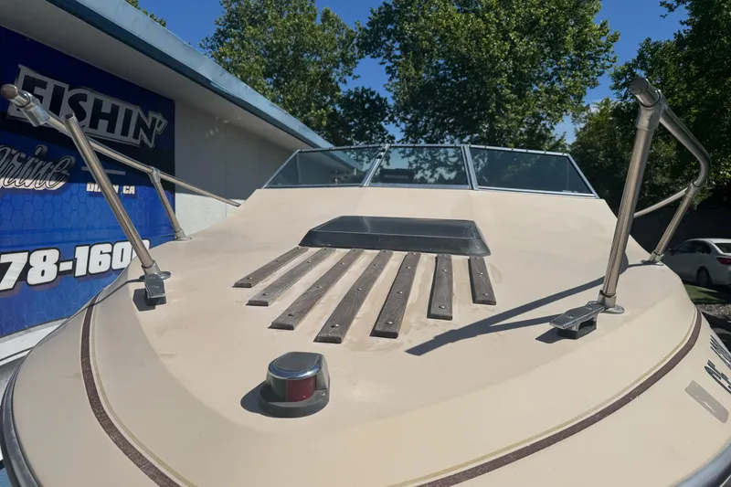Slide: The Image of 1985 Invader 20 boat bow with windshield, railings, and wooden accents under clear sky. - 6