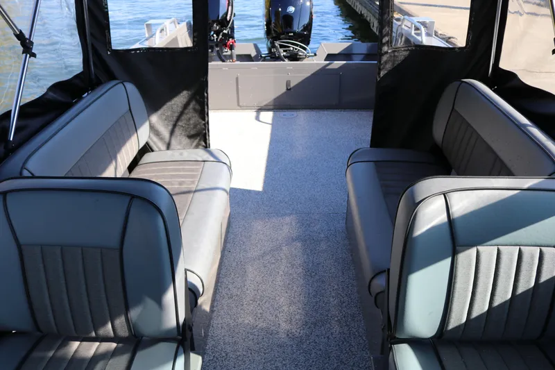 Slide: The Image of 2026 Alumaweld Stryker 220 boat interior with cushioned seating and outboard motor. - 37