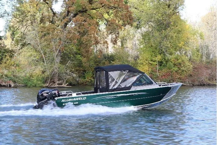 Slide: The Image of 2026 Alumaweld Stryker 220 boat cruising on a scenic river with lush trees. - 41