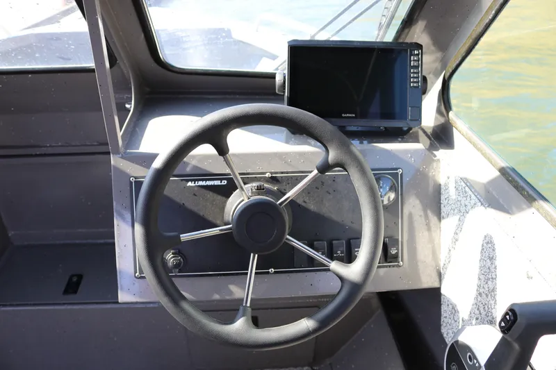 Slide: The Image of Steering wheel and dashboard of 2026 Alumaweld Stryker 220 boat with navigation display. - 7