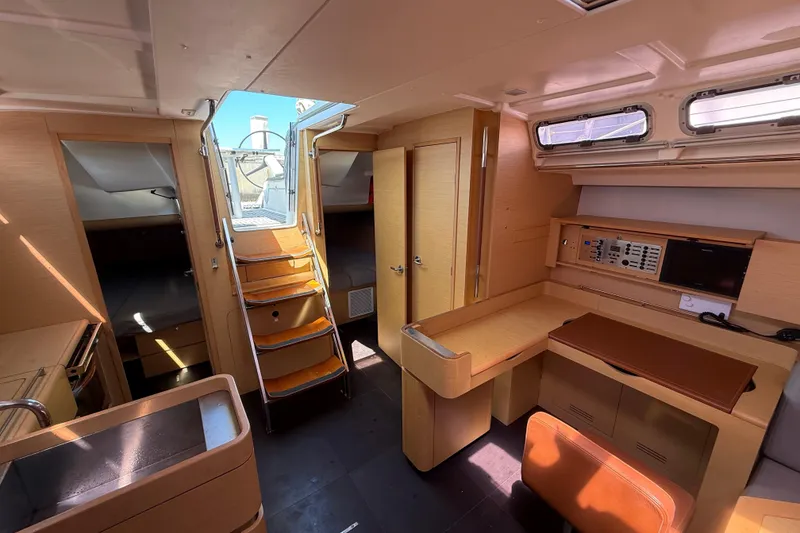 Slide: The Image of Interior of 2008 Beneteau First 50 yacht, featuring modern wood finish and navigation station. - 26