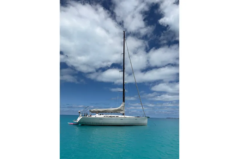 Slide: The Image of Sailing yacht Beneteau First 50, 2008 model, anchored in turquoise waters under a cloudy sky. - 3