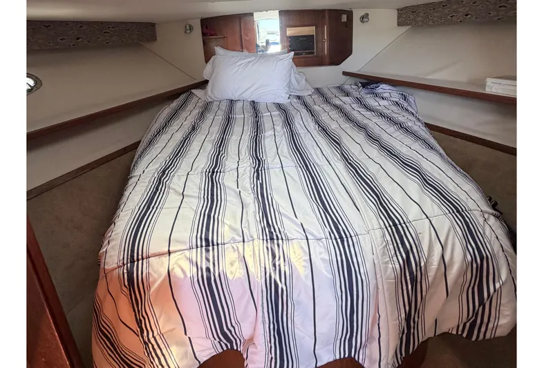 Slide: The Image of Tiara Yachts 3500 Open 2001 cabin with striped bedding. - 11