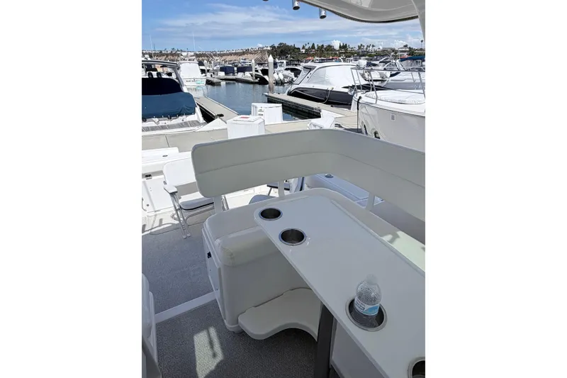 Slide: The Image of 2001 Tiara Yachts 3500 Open at marina, featuring spacious seating and cup holders. - 7