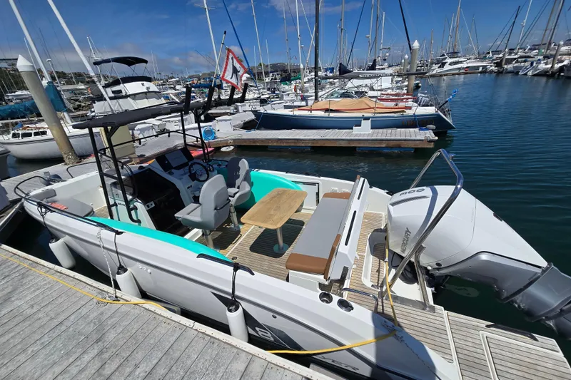 Slide: The Image of 2023 Beneteau Flyer 8 SPACEdeck boat docked in a marina, showcasing seating and outboard motor. - 6