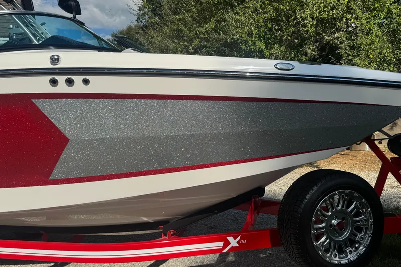 Slide: The Image of 2020 MasterCraft XStar boat with red and silver glitter design on a trailer. - 26