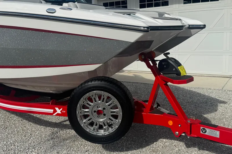Slide: The Image of 2020 MasterCraft XStar boat on red trailer, close-up view of hull and wheel. - 3