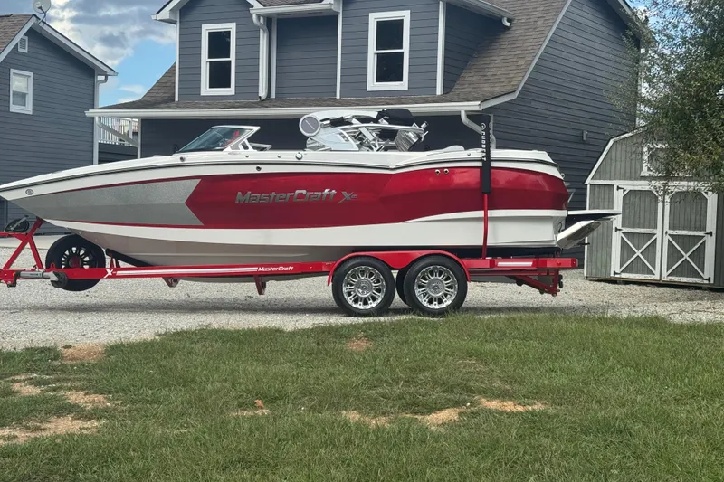 Slide: The Image of 2020 MasterCraft XStar boat on trailer in front of gray house. - 4