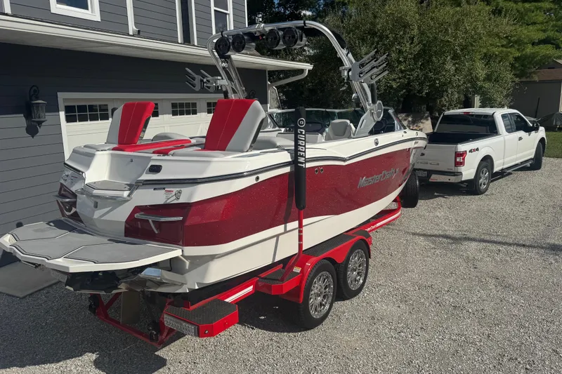 Slide: The Image of 2020 MasterCraft XStar boat on trailer, parked beside a white truck. - 6