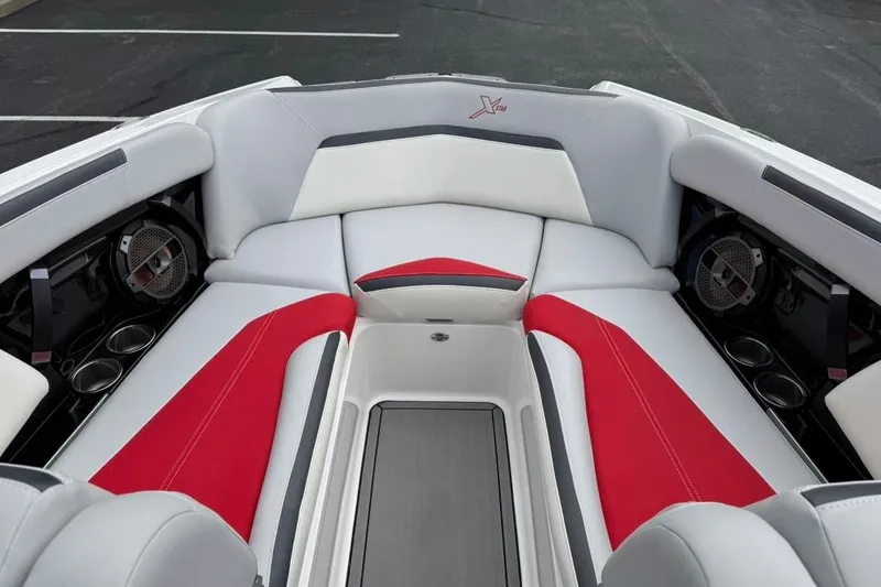 Slide: The Image of 2020 MasterCraft XStar boat interior with red and white seating, cup holders, and speakers. - 9
