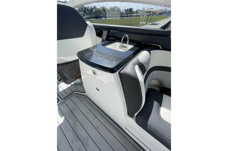Slide: The Image of 2021 Yamaha Boats 275SE interior with sleek seating and compact sink area. - 18