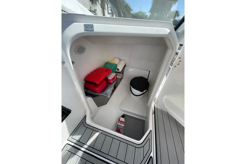 Slide: The Image of 2021 Yamaha Boats 275SE storage compartment with safety gear and accessories. - 21