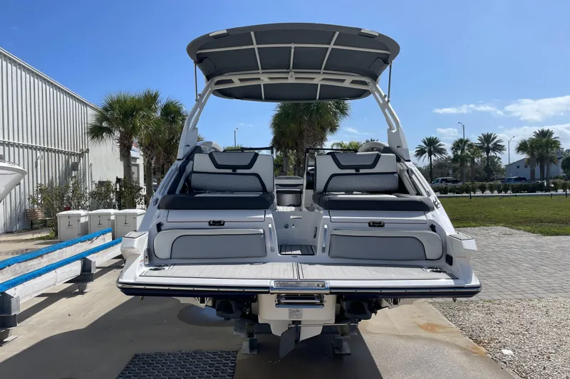 Slide: The Image of 2021 Yamaha Boats 275SE with sleek design, docked under clear blue sky. - 3