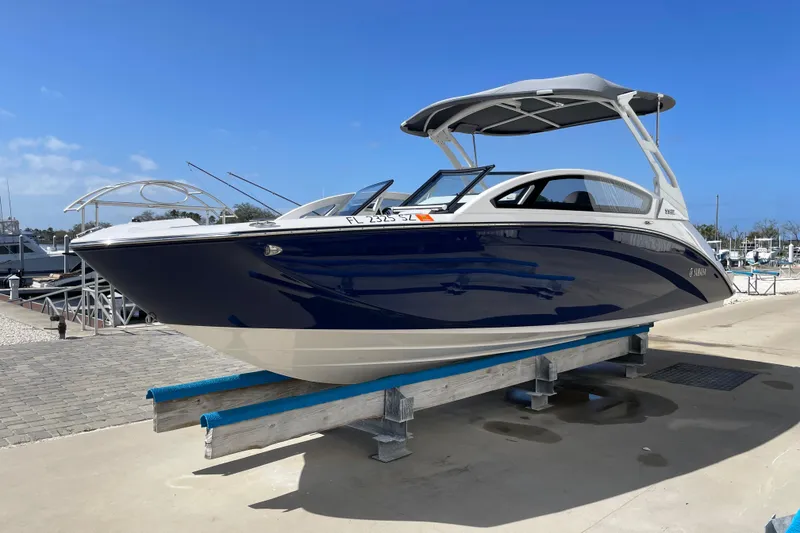 Slide: The Image of 2021 Yamaha Boats 275SE on display at a marina, featuring sleek blue and white design. - 6