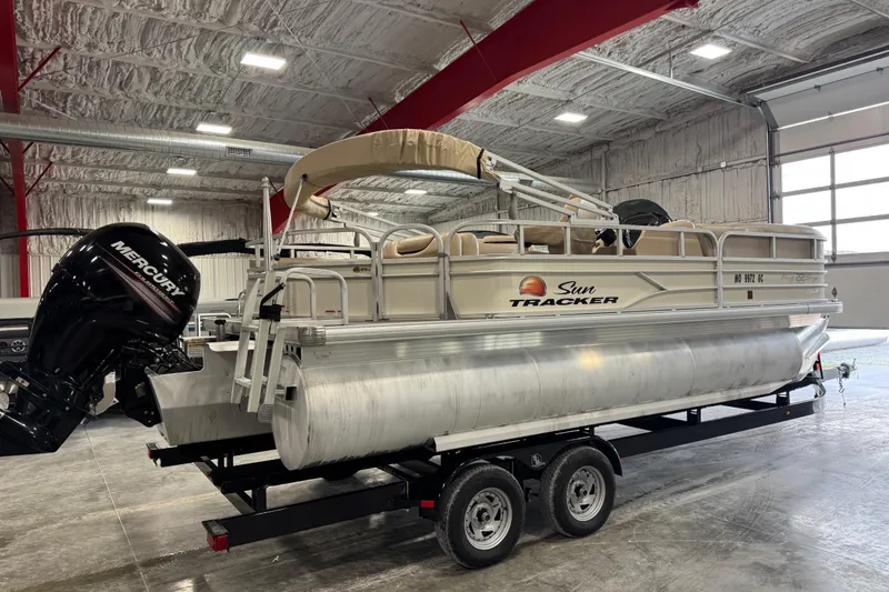 Slide: The Image of 2016 Sun Tracker Party Barge 22 XP3 pontoon boat in indoor storage, featuring Mercury outboard motor. - 4