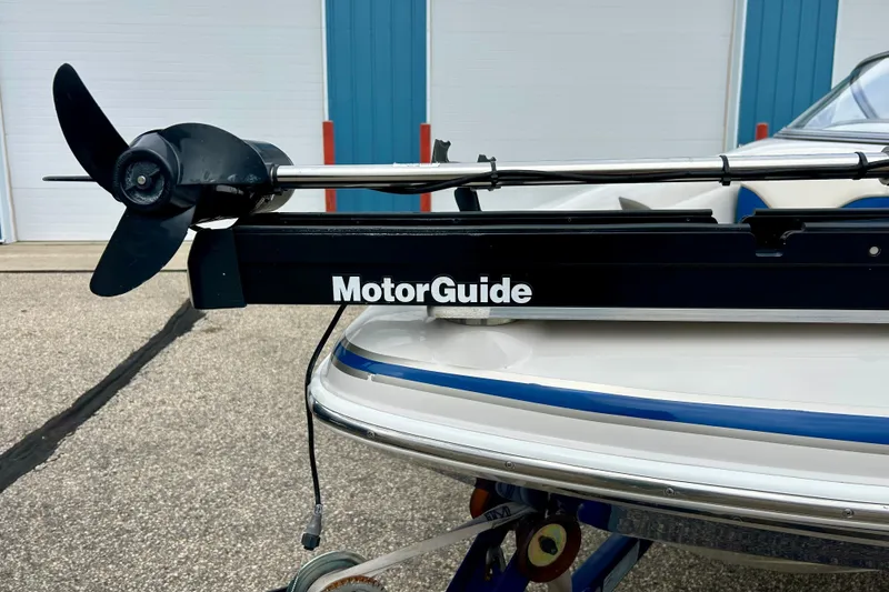 Slide: The Image of MotorGuide trolling motor on 2004 Tahoe Q4 boat, parked near blue and white building. - 12