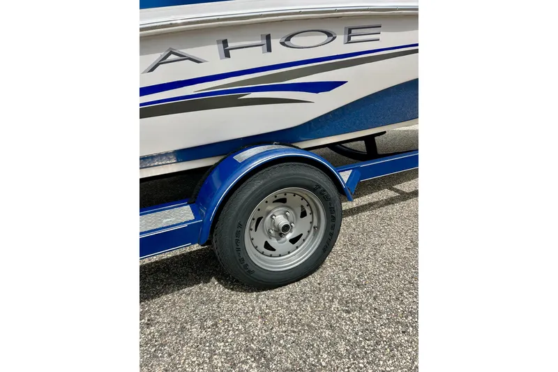 Slide: The Image of 2004 Tahoe Q4 boat trailer with blue accents and visible tire on pavement. - 15