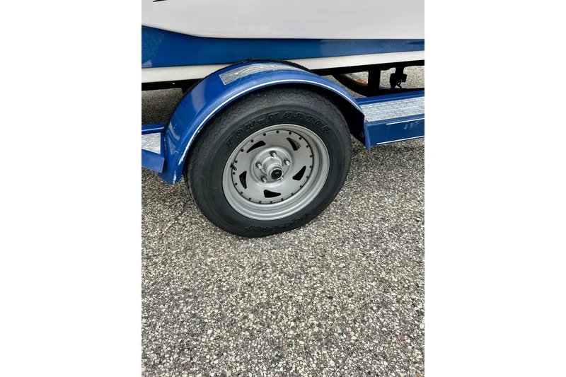 Slide: The Image of Close-up of a 2004 Tahoe Q4 trailer wheel on a textured pavement. - 16