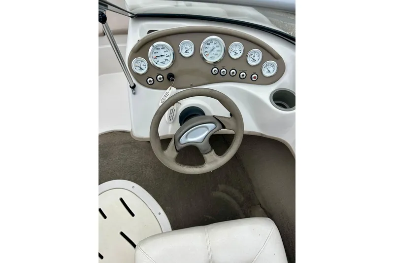 Slide: The Image of Steering wheel and dashboard of a 2004 Tahoe Q4 boat with gauges and controls. - 20