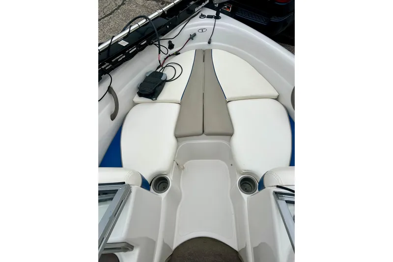 Slide: The Image of 2004 Tahoe Q4 boat interior with white and blue seating, cup holders, and equipment. - 23