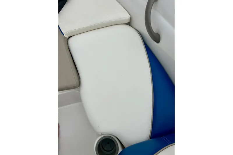 Slide: The Image of 2004 Tahoe Q4 boat seat with white and blue upholstery, featuring a cup holder. - 25