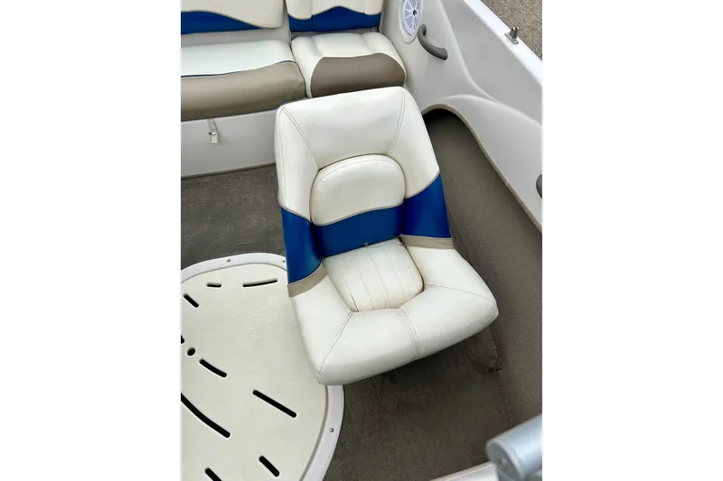 Slide: The Image of 2004 Tahoe Q4 boat interior with white and blue cushioned seating. - 28