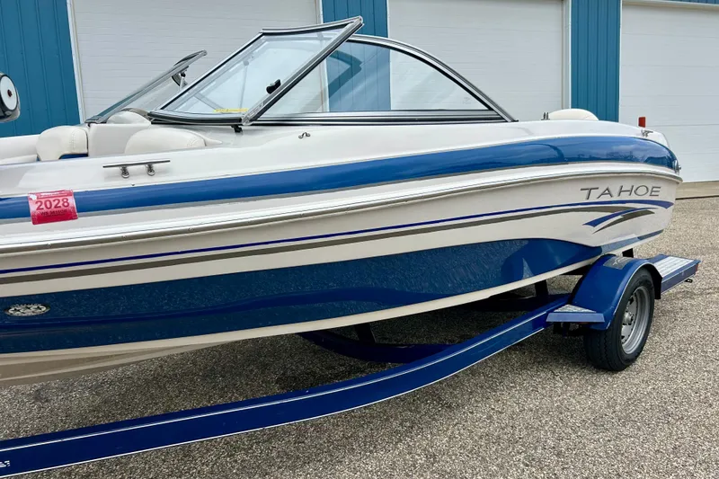 Slide: The Image of 2004 Tahoe Q4 boat with blue and white design on a trailer. - 3