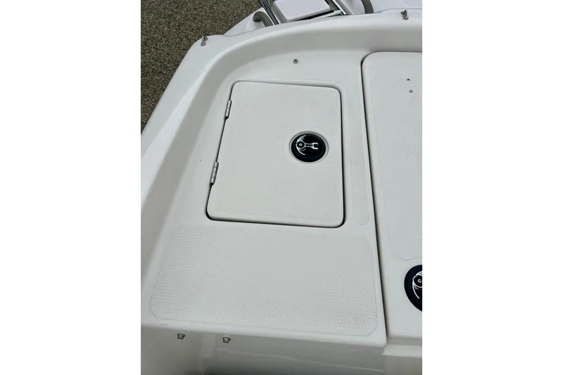 Slide: The Image of 2004 Tahoe Q4 boat storage compartment with textured white surface and circular latch. - 32