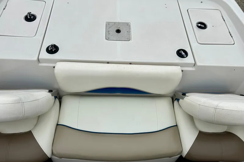 Slide: The Image of 2004 Tahoe Q4 boat interior with white and beige seating, featuring storage compartments. - 35
