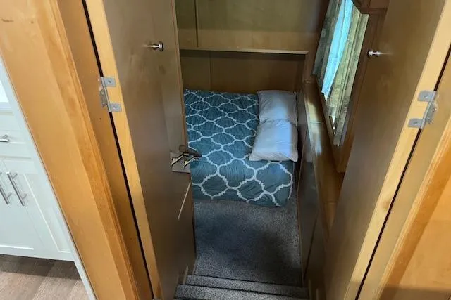 Slide: The Image of Cozy bedroom in 2003 Fantasy 18x80 houseboat with patterned bedding and wooden interior. - 18