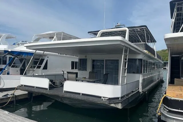 Slide: The Image of 2003 Fantasy 18x80 Houseboat docked, featuring spacious deck and modern design. - 2