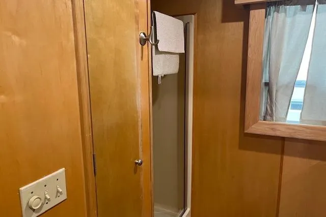 Slide: The Image of Interior of 2003 Fantasy 18x80 Houseboat featuring a compact shower and wooden paneling. - 23