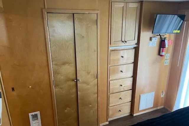 Slide: The Image of Interior of 2003 Fantasy 18x80 Houseboat with wooden cabinets and wall-mounted TV. - 25