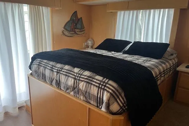 Slide: The Image of Cozy bedroom in 2003 Fantasy 18x80 houseboat with plaid bedding and nautical decor. - 26
