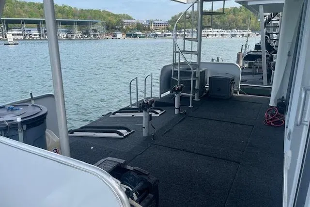 Slide: The Image of 2003 Fantasy 18x80 Houseboat docked on a serene lake with marina view. - 29