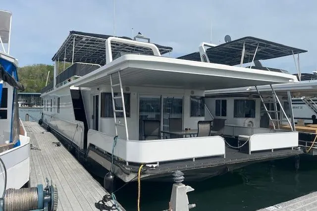 Slide: The Image of 2003 Fantasy 18x80 Houseboat docked, featuring spacious deck and modern design. - 3
