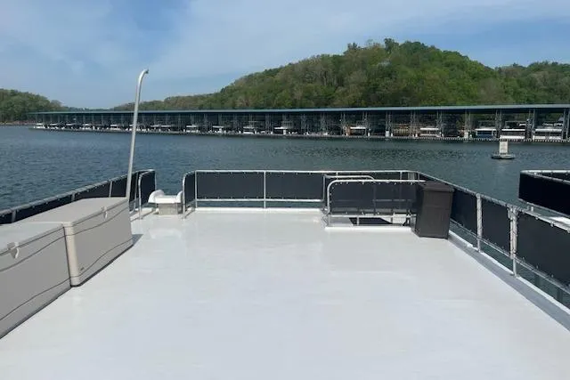 Slide: The Image of 2003 Fantasy 18x80 Houseboat on serene lake with marina and lush green hills. - 30