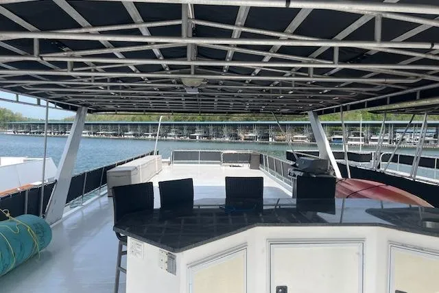 Slide: The Image of 2003 Fantasy 18x80 Houseboat with spacious deck and seating area on the water. - 31