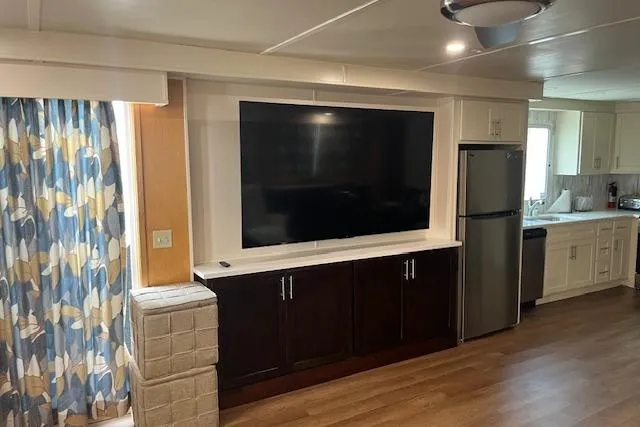 Slide: The Image of Interior of 2003 Fantasy 18x80 Houseboat with TV, cabinets, and kitchen area. - 7